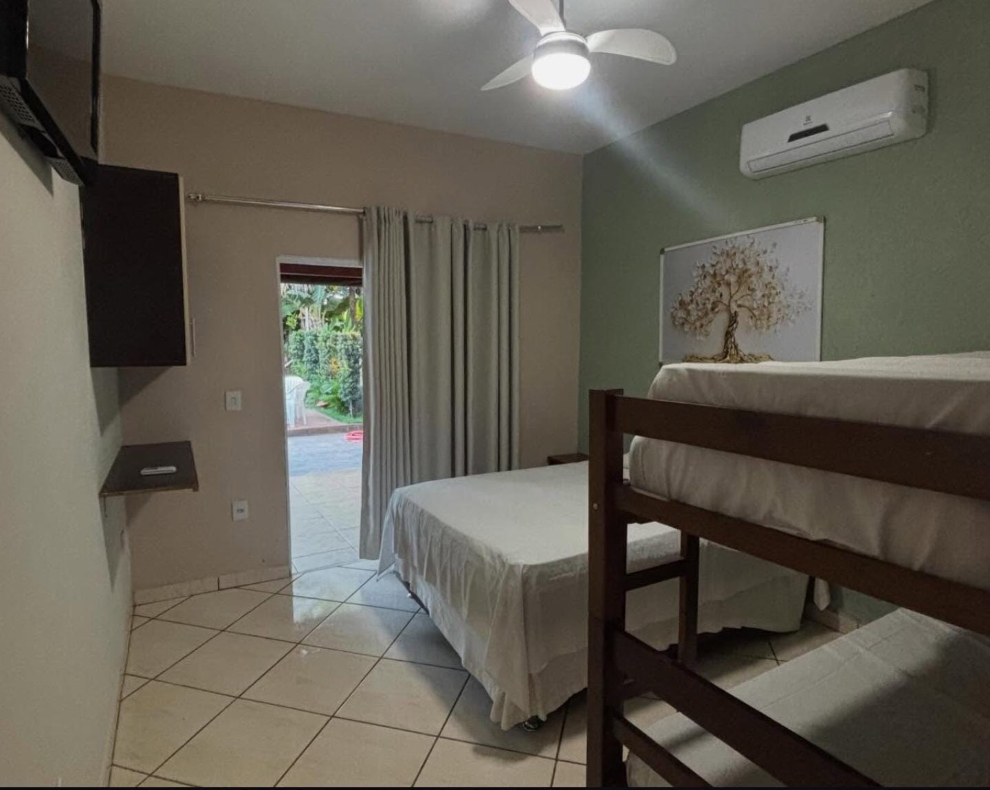 Quarto com cama de casal, beliche e ar-condicionado no Recanto Dokmos